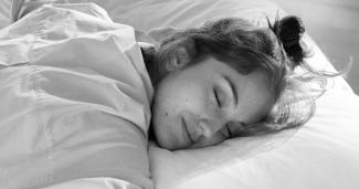 Eine Frau schläft auf einem grossen Kopfkissen